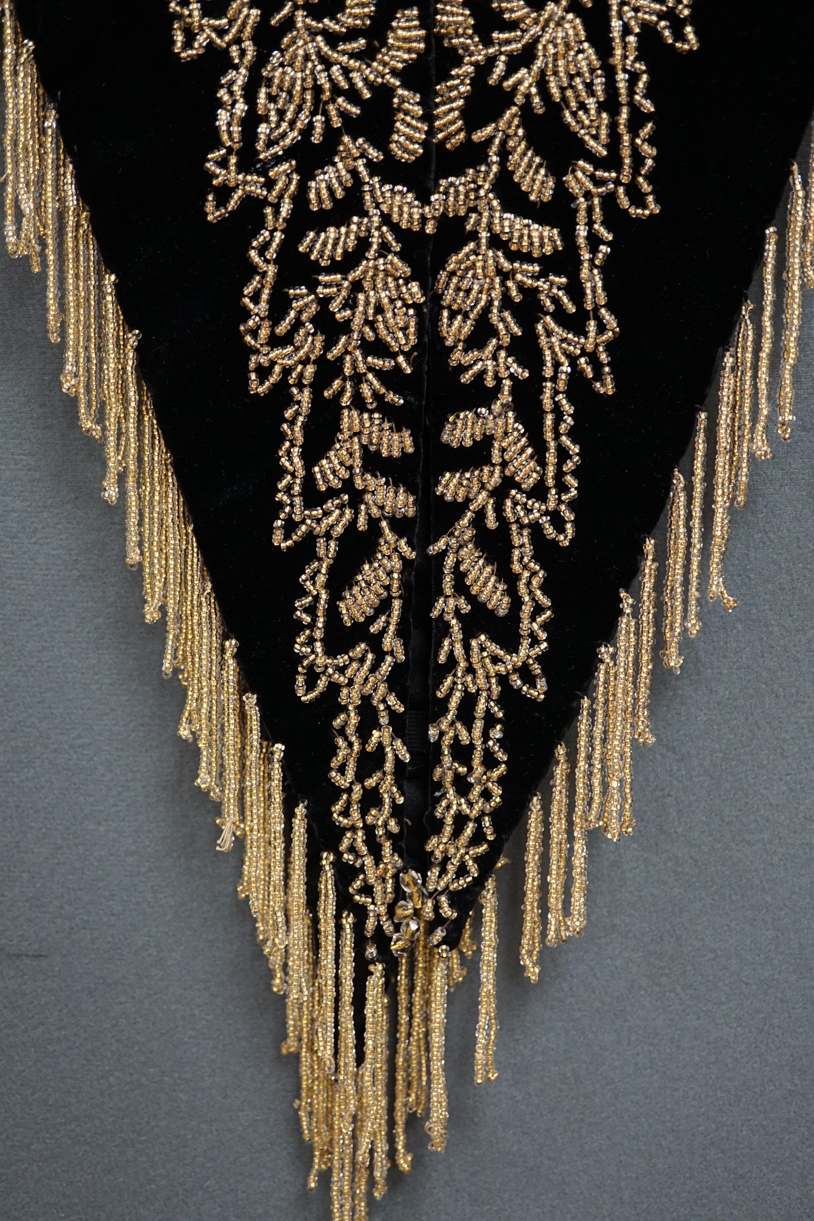 An Edwardian French black velvet and elaborately beaded evening over collar, with makers label, ‘Fillet’, designed with a high collar, front and back panels, all heavily bead worked in an intricate floral design, attache